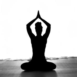Women in silhouette yoga pose. 
